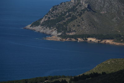 Scenic view of sea and mountains against blue sky