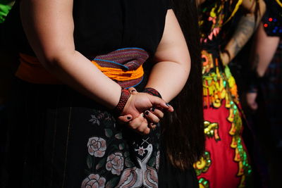 Midsection of woman with hands behind back