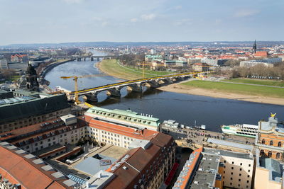 High angle view of river amidst buildings in city against sky