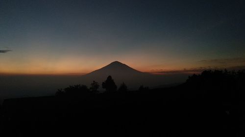 Scenic view of silhouette mountains against clear sky during sunset