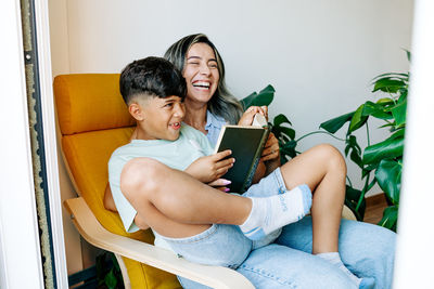 Young woman using laptop while sitting on sofa at home