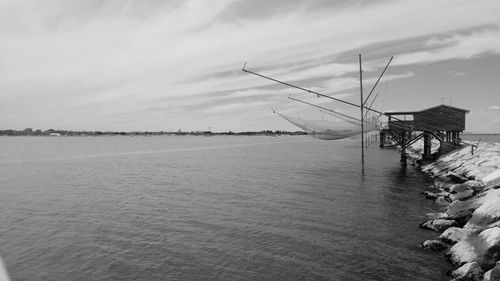 Fishing nets on lake against sky