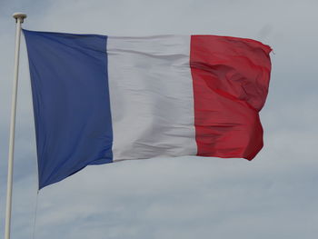Low angle view of french flag waving against sky