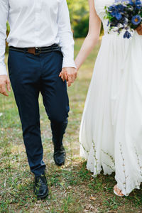 Low section of couple holding hands