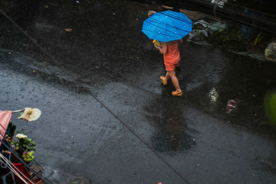 High angle view of wet holding umbrella during rainy season