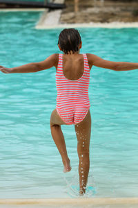 Rear view of girl in swimming pool