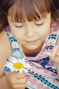 Close-up of young woman holding yellow flower