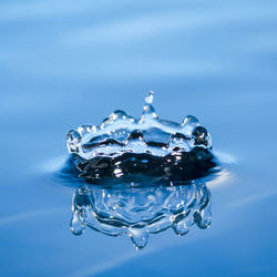 Close-up of drop splashing on blue water