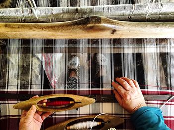 Low section of person weaving wool