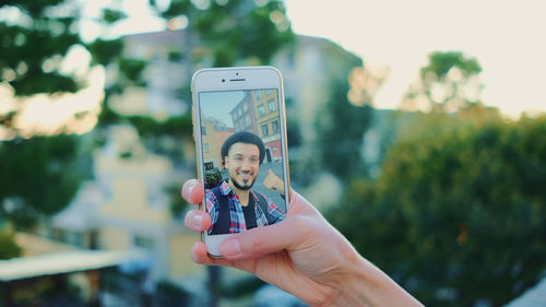 Man doing selfie with mobile phone outdoors