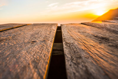 Close-up of wooden plank against sky during sunset