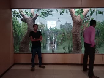 Full length of young man looking through window