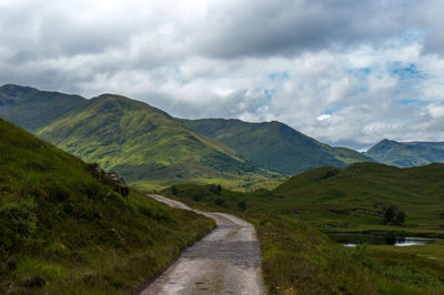 Scenic view of road amidst mountains against sky