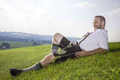 Young man on field against sky