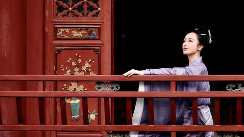 Portrait of young woman standing by window