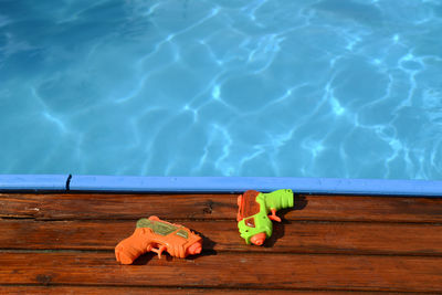 High angle view of squirt guns by swimming pool