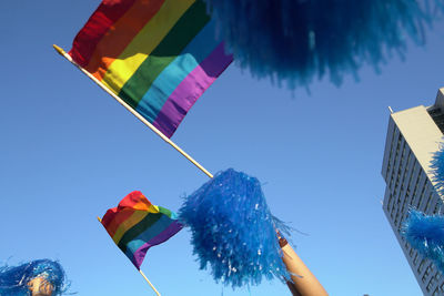 Low angle view of flags against clear blue sky