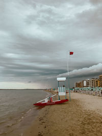 Lifeguard hut on beach against sky