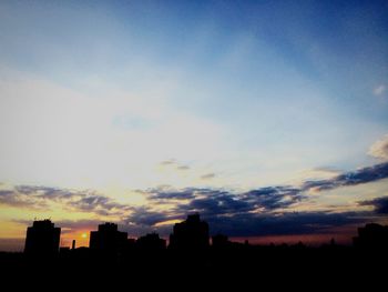 Silhouette of buildings against sky at sunset