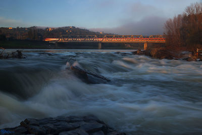 Scenic view of river against sky at sunset