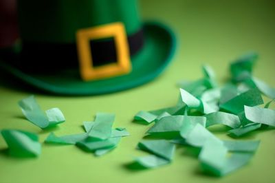 High angle view of papers with hat on green background