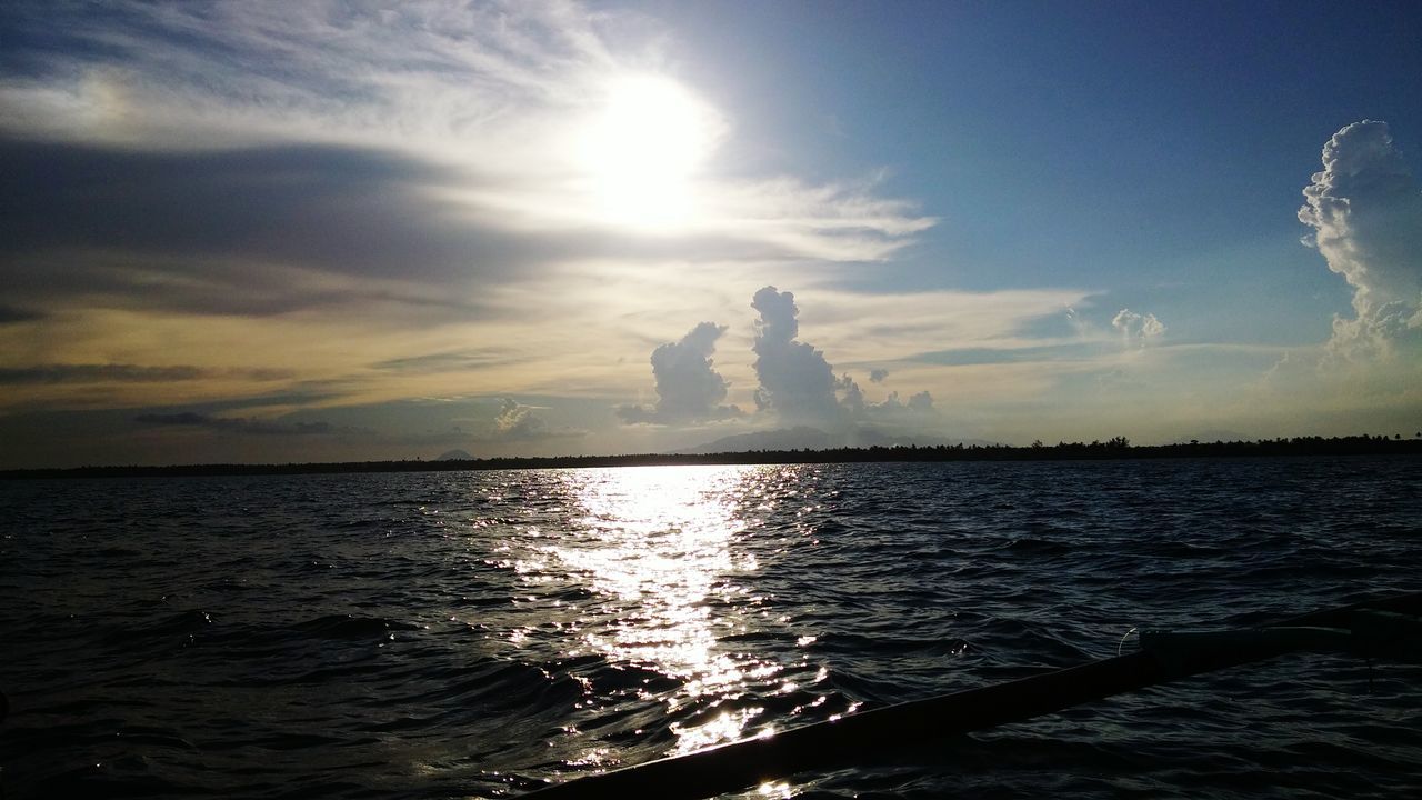 water, tranquil scene, sky, scenics, waterfront, tranquility, sun, beauty in nature, reflection, sea, sunlight, rippled, nature, cloud - sky, sunbeam, idyllic, cloud, sunset, outdoors, silhouette