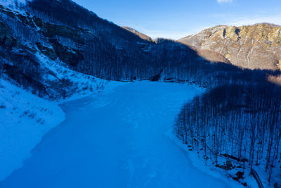 Scenic view of snowcapped mountains against blue sky
