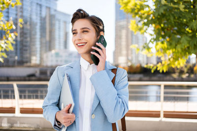 Portrait of young businesswoman standing outdoors