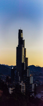 Buildings in city against sky during sunset