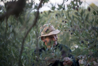 Mature man standing amidst trees at forest