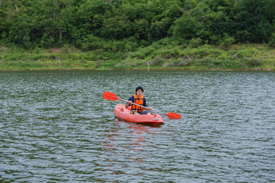 People rowing boat in river