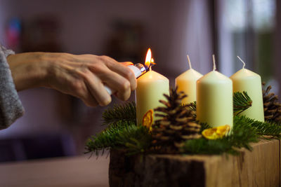 Close-up of hand holding lit candles