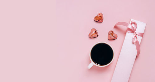 Chocolate candies hearts festive box coffee cup pink background. holiday concept february 14 