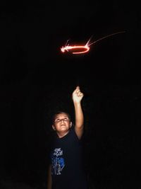 Boy holding firework at night