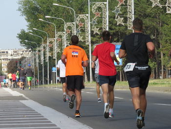 Rear view of people walking on road