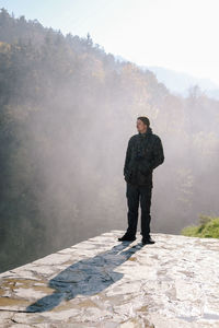 Full length of man standing against forest