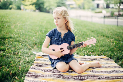 Full length of a man playing guitar on field