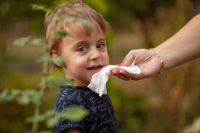 Portrait of cute boy holding outdoors