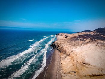 Scenic view of beach against blue sky