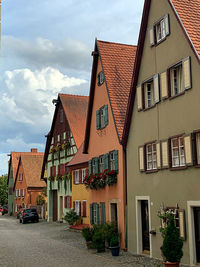 Houses by street in town against sky