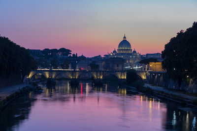 Arch bridge over river against buildings in city