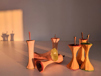 Close-up of candles on table against wall