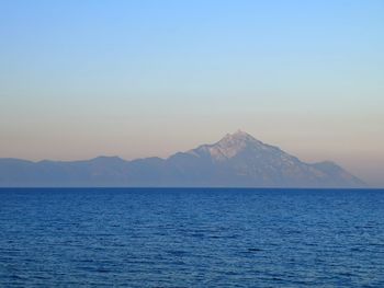 Scenic view of sea and mountains against clear sky