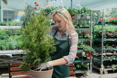 Portrait of young woman standing in greenhouse