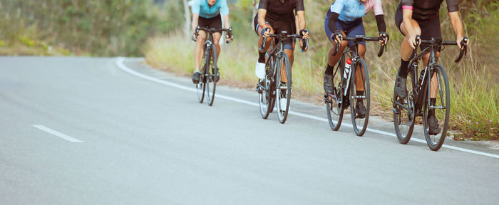 Low section of people riding bicycle on road