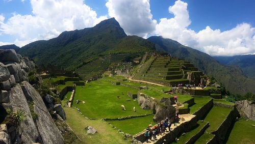 Panoramic view of green landscape and mountains against sky