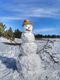 White sculpture on snow covered field against sky