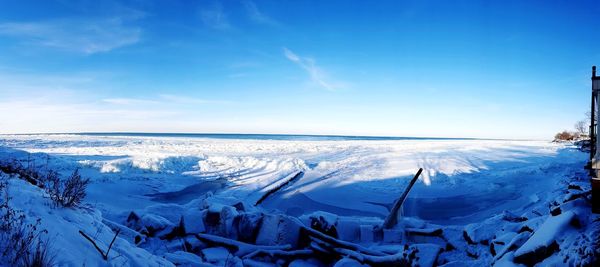 Scenic view of frozen landscape against blue sky