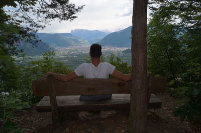 Rear view of man sitting on mountain
