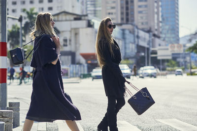 Woman with umbrella on street in city